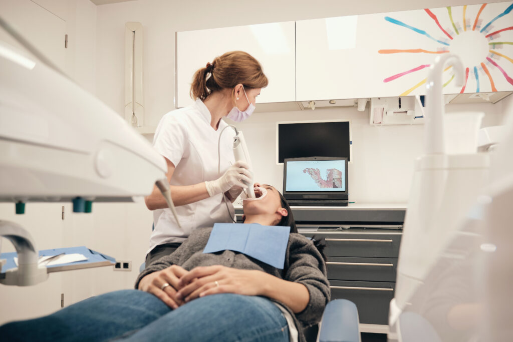 Female dentist scanning teeth of woman